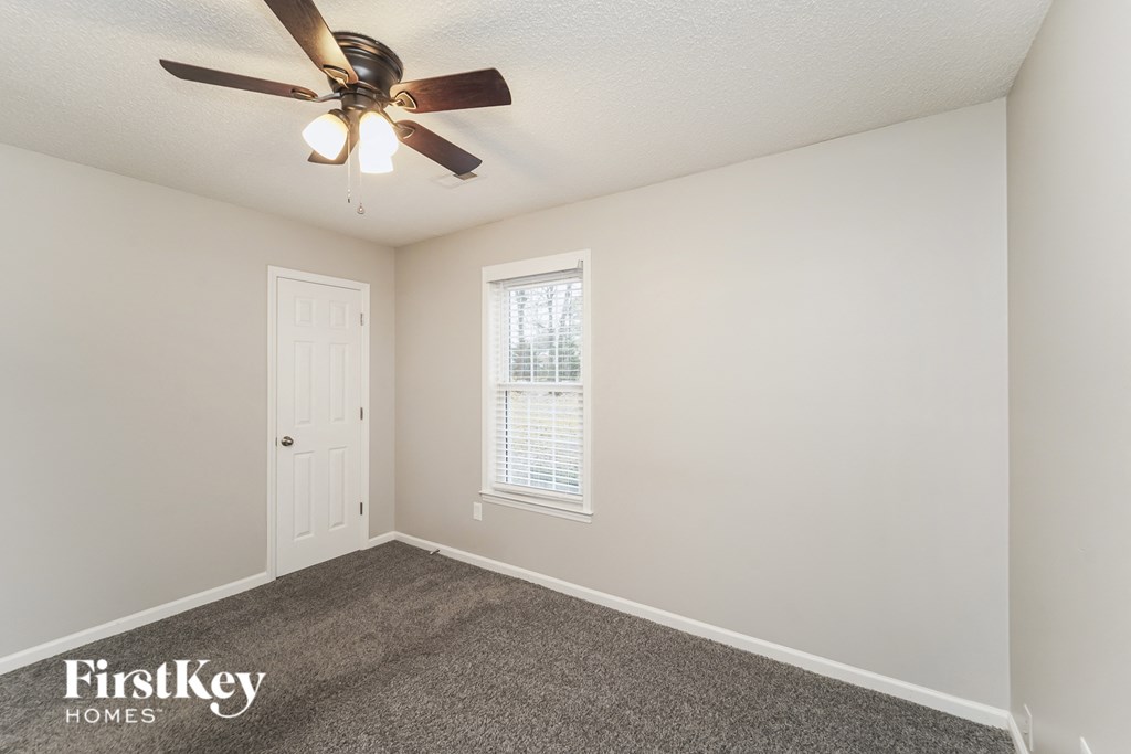 a bedroom with a ceiling fan and a white door