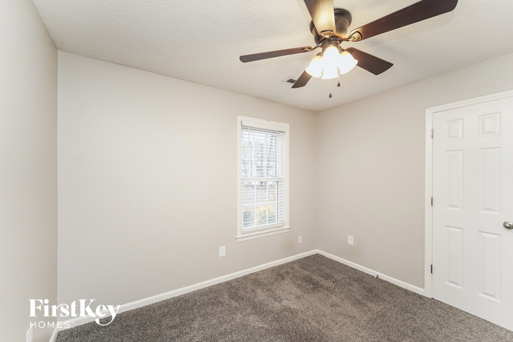 a bedroom with carpet and a ceiling fan