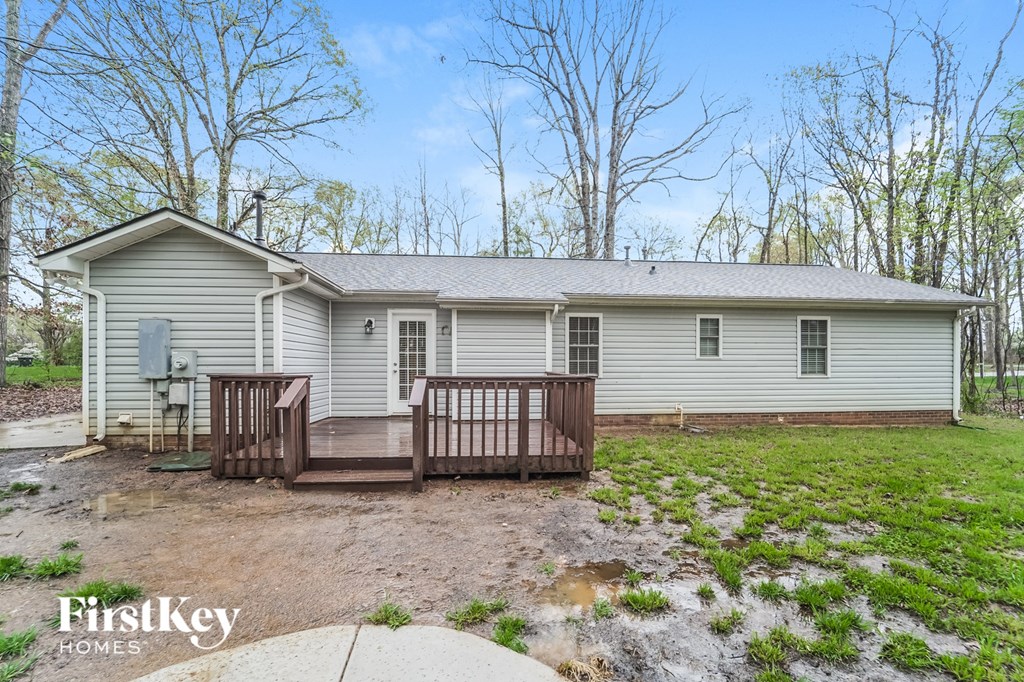 a small white house with a deck and a yard