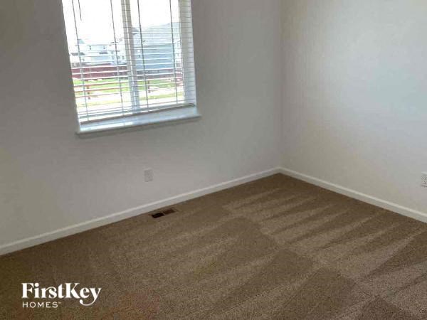 an empty room with a window and a carpet
