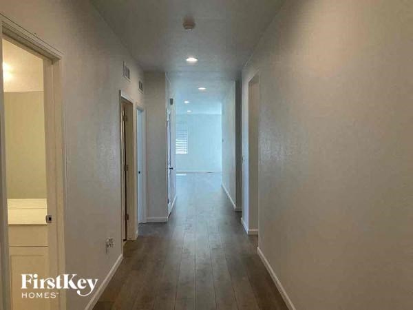 a long hallway with white walls and wooden floors