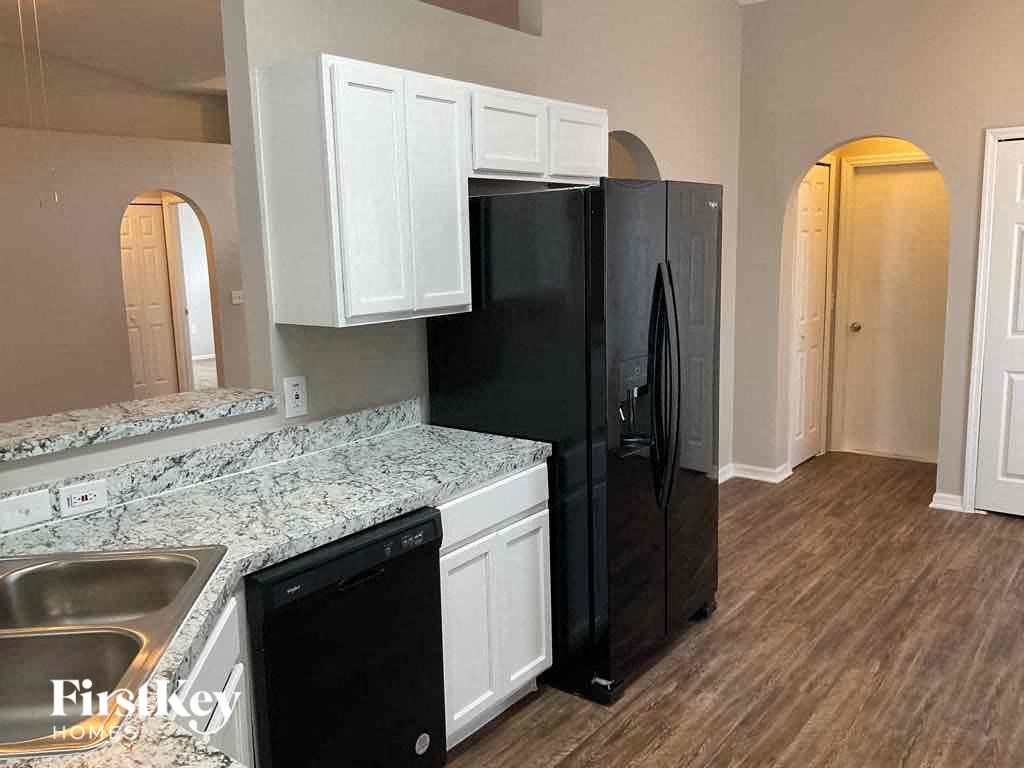 a kitchen with a black refrigerator and a sink