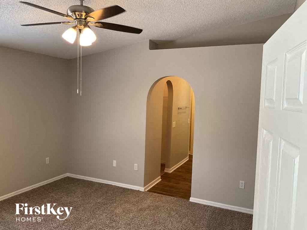 an arched doorway in an empty room with a ceiling fan