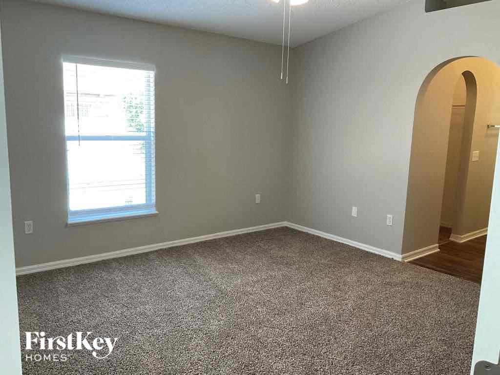 an empty room with a window and a carpeted floor