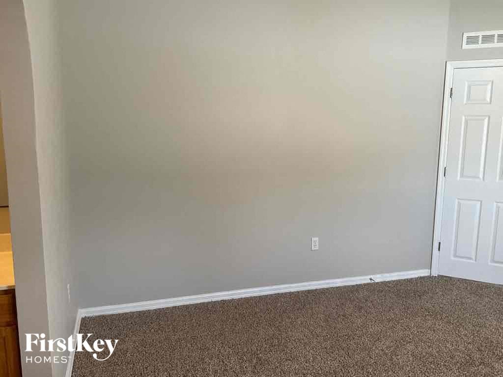 an empty room with a carpeted floor and a white door