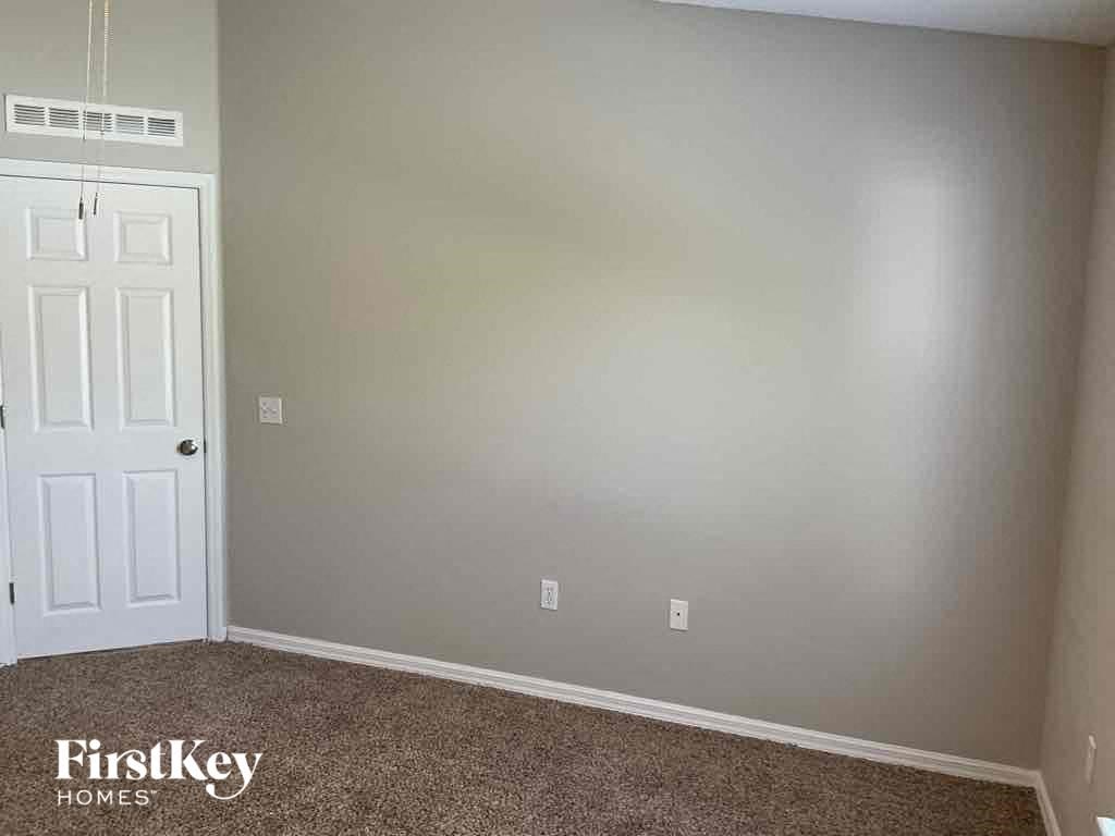 an empty room with a white door and a carpet