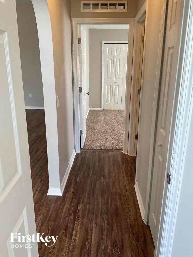 a hallway with a hard wood floor and a white door