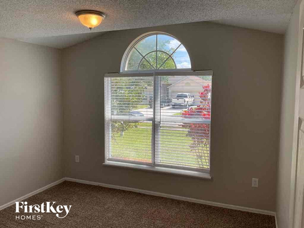 an empty room with a large window with a street view