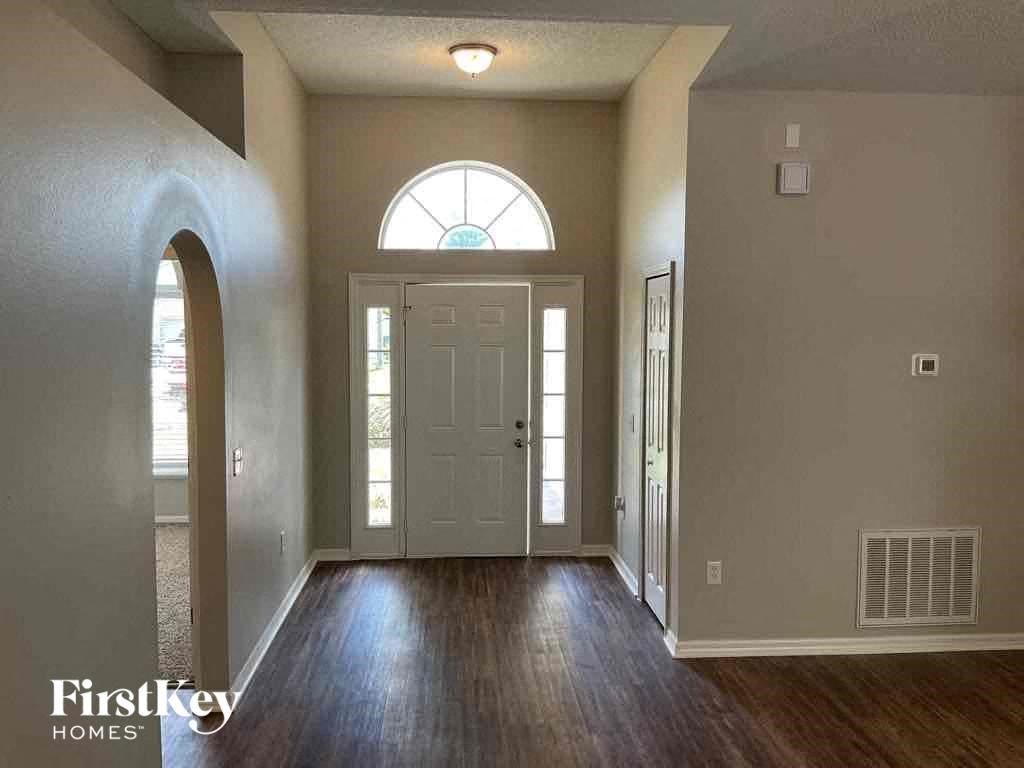 an empty living room with a white door and a window