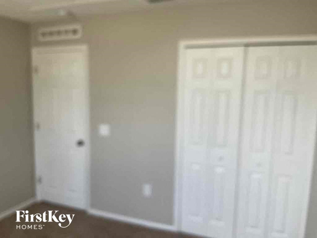 a bedroom with two white doors and a closet