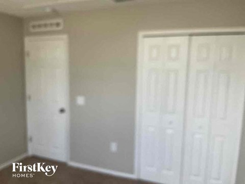 a bedroom with two white doors and a closet