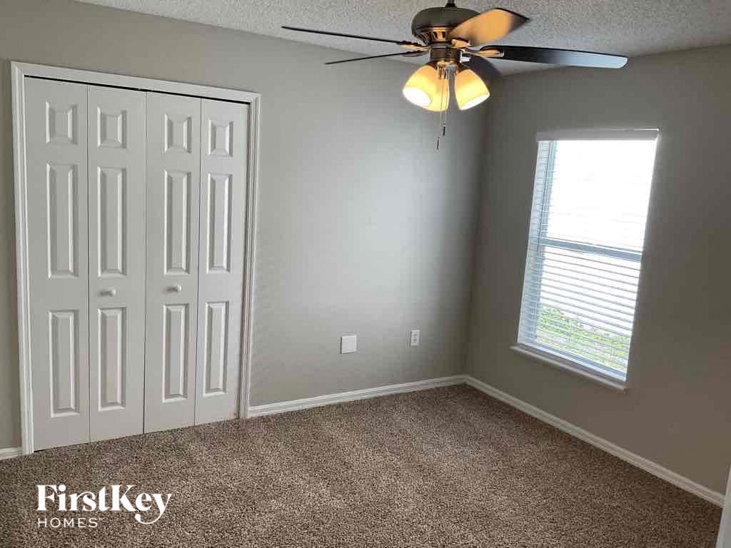 a gray room with a ceiling fan and a white door
