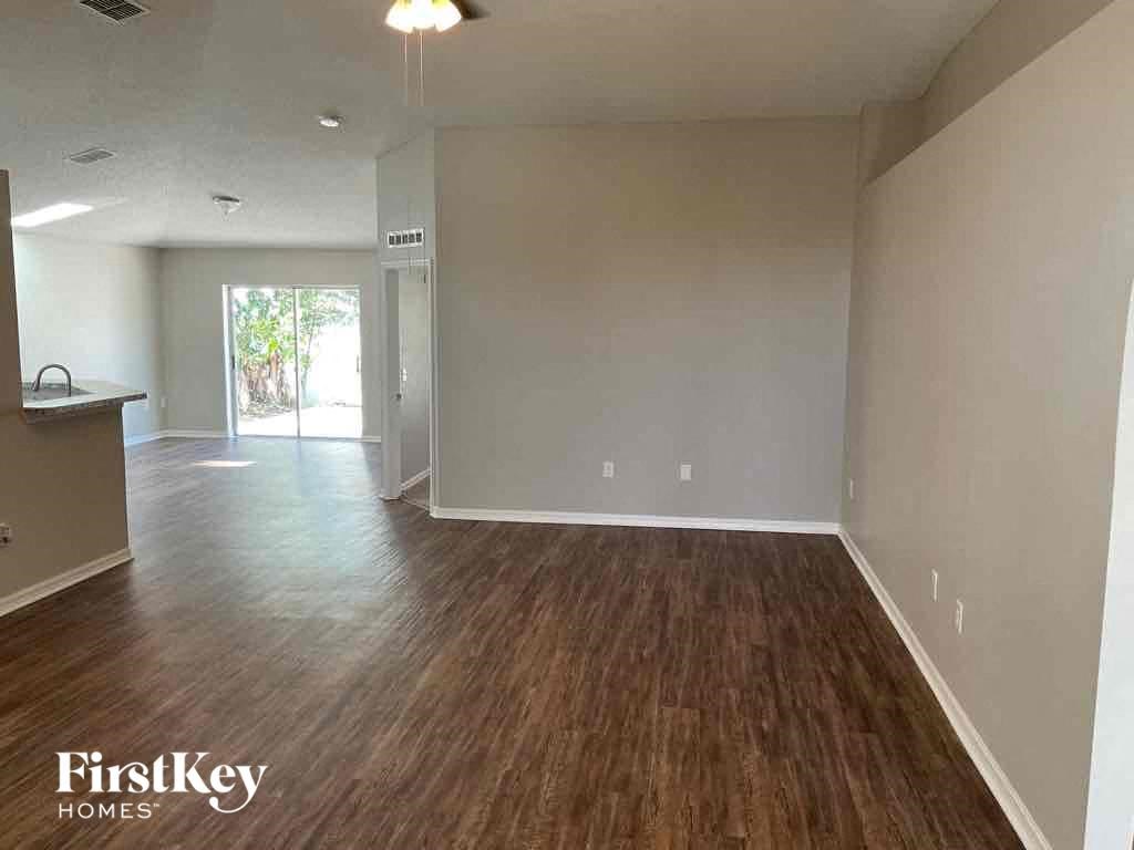 an empty living room and dining room with wood flooring