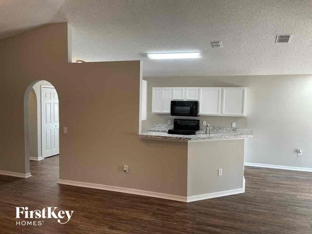an empty kitchen with a counter top and a microwave