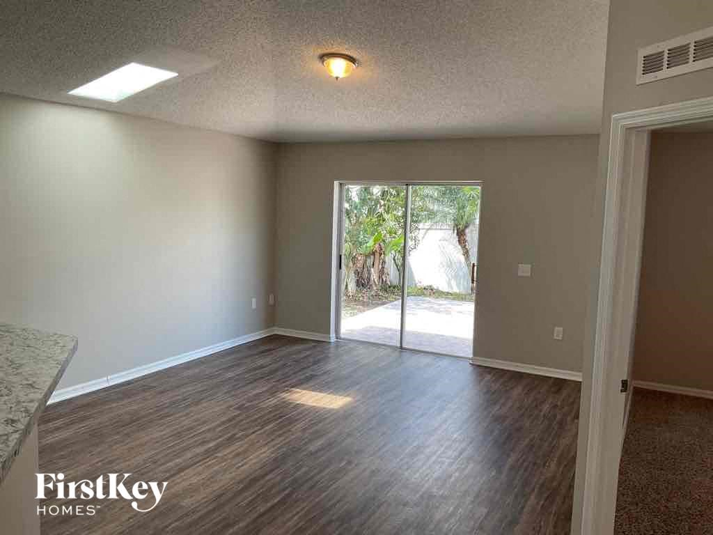 an empty living room with a sliding glass door to a patio