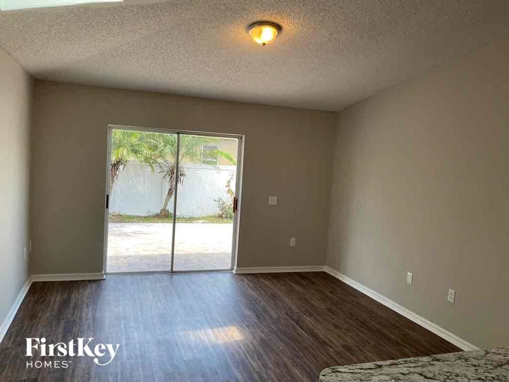 an empty living room with a sliding glass door to a patio