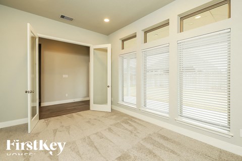 A room with a carpeted floor and a doorway leading to another room.
