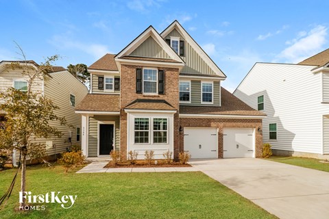 a brick house with white siding and a white garage door