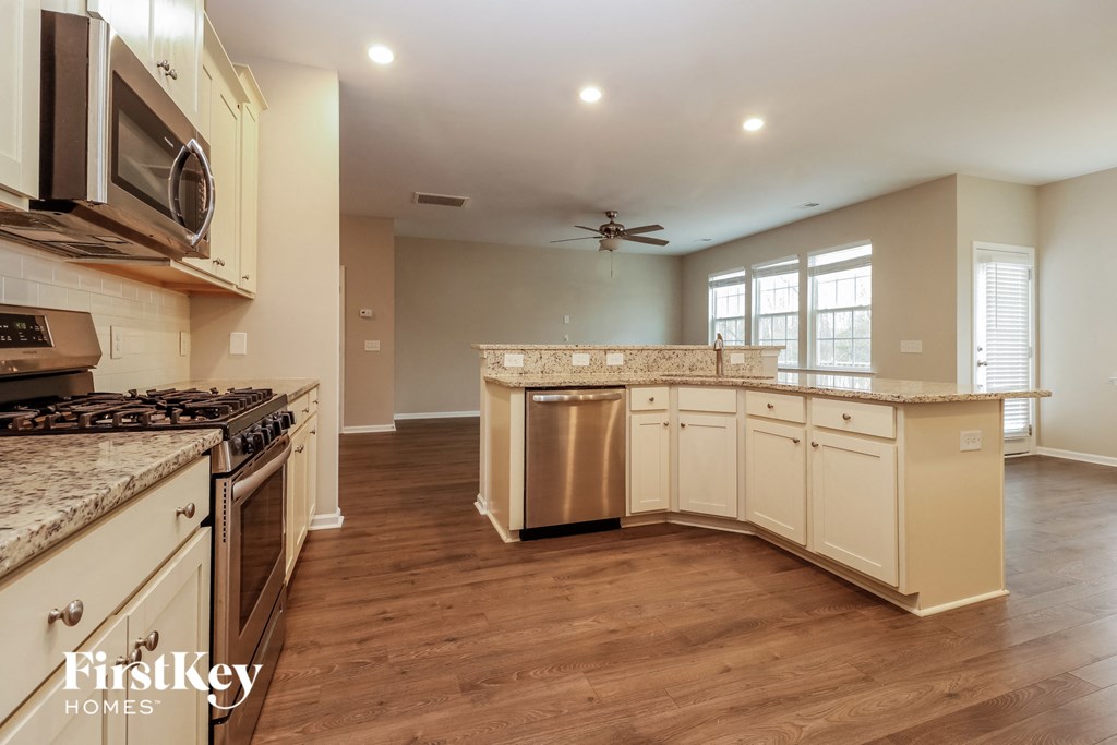 a kitchen with white cabinets and stainless steel appliances