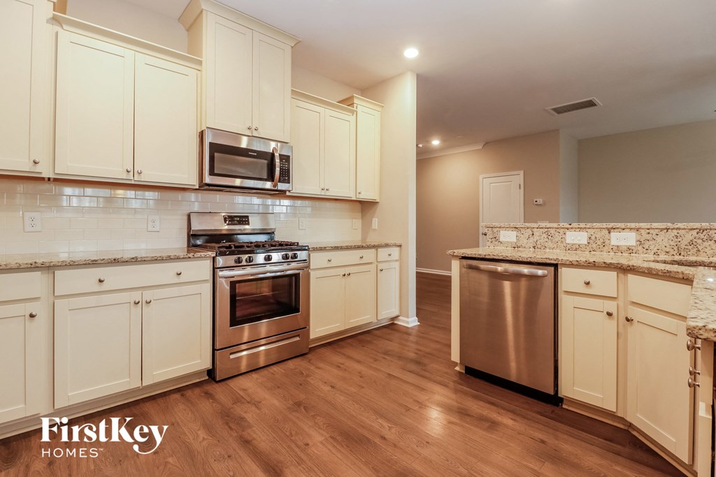 a kitchen with white cabinets and stainless steel appliances