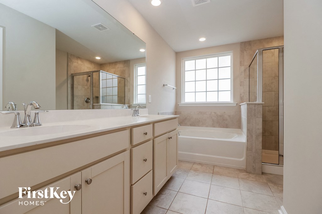 a bathroom with two sinks and a shower and a tub