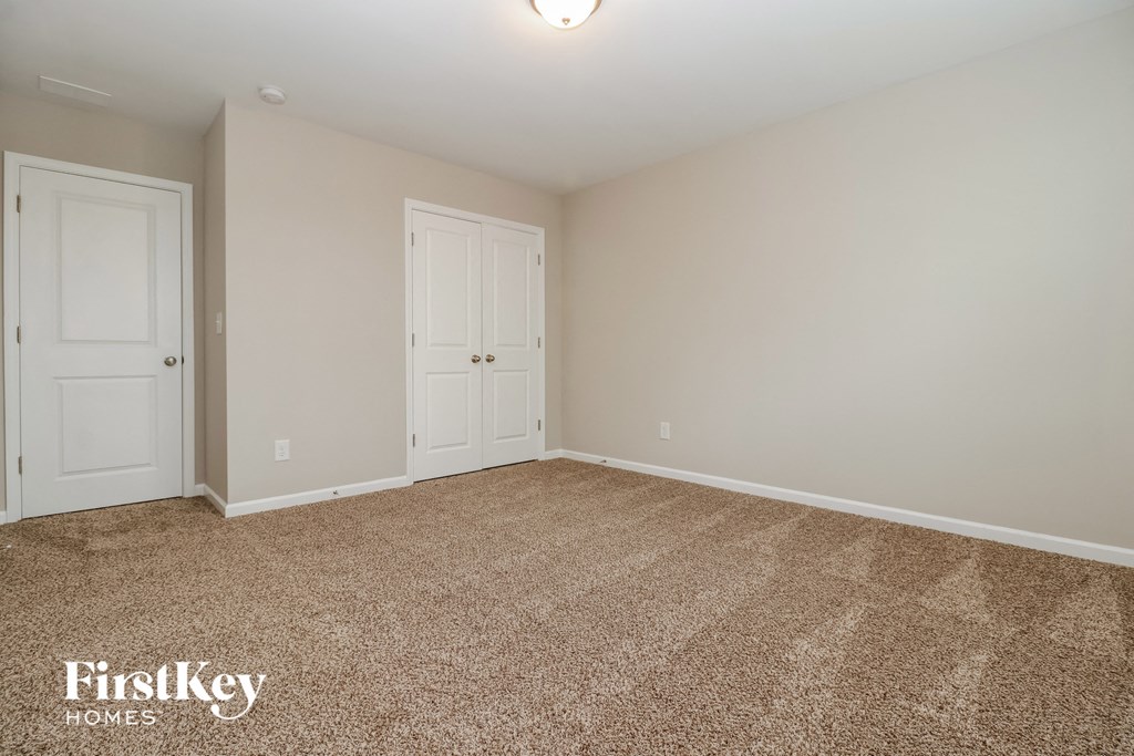 a bedroom with two doors and a carpeted floor