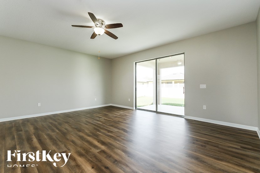 A room with a ceiling fan and wooden flooring.