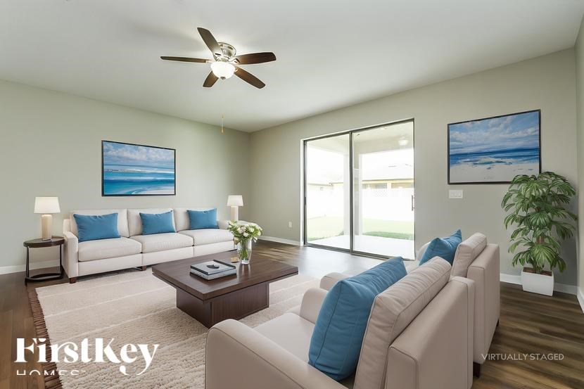 A living room with a couch, a coffee table, and a ceiling fan.
