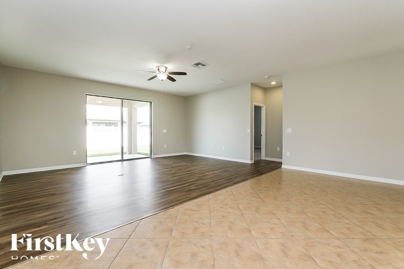 A spacious room with wooden flooring and a ceiling fan.