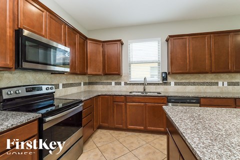 A kitchen with wooden cabinets and a granite countertop.