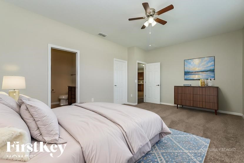 A bedroom with a large bed and a ceiling fan.