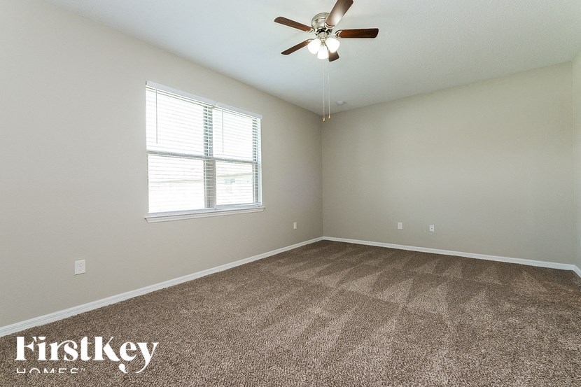 A room with a ceiling fan and a window.