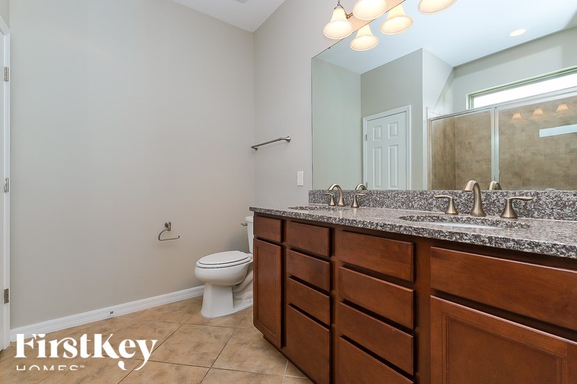A bathroom with a toilet, sink, and mirror.