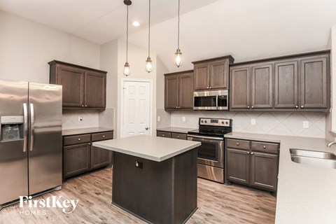A kitchen with wooden cabinets and a stainless steel refrigerator.
