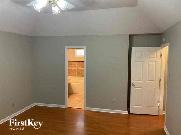 A room with a wooden floor and a white door.