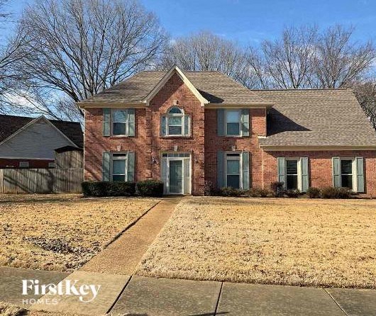 A brick house with a First Key Homes sign in front.