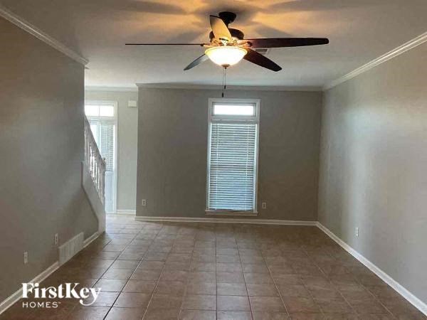 A room with a ceiling fan and tiled floor.