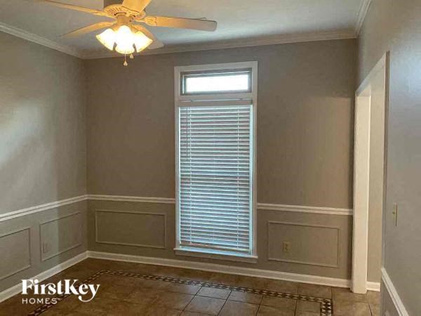 A room with a ceiling fan and a window with blinds.