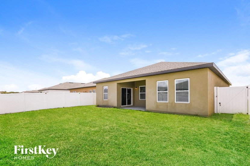 a home with a grass yard and a white fence