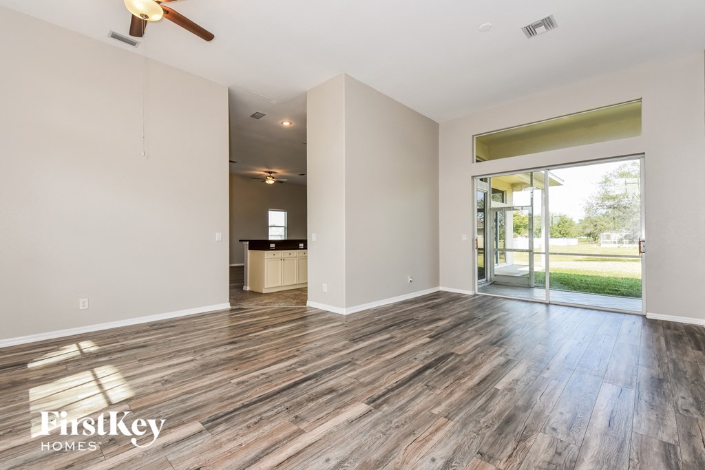 the living room with wood flooring and sliding glass doors to the patio