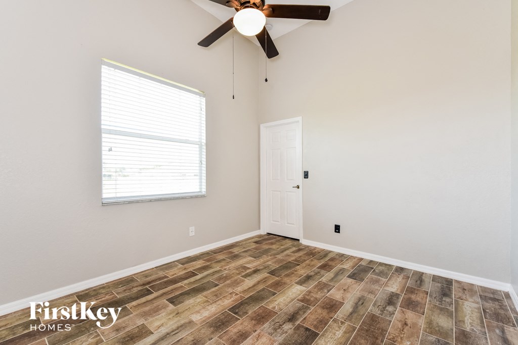 the living room of a home with wood flooring and a ceiling fan