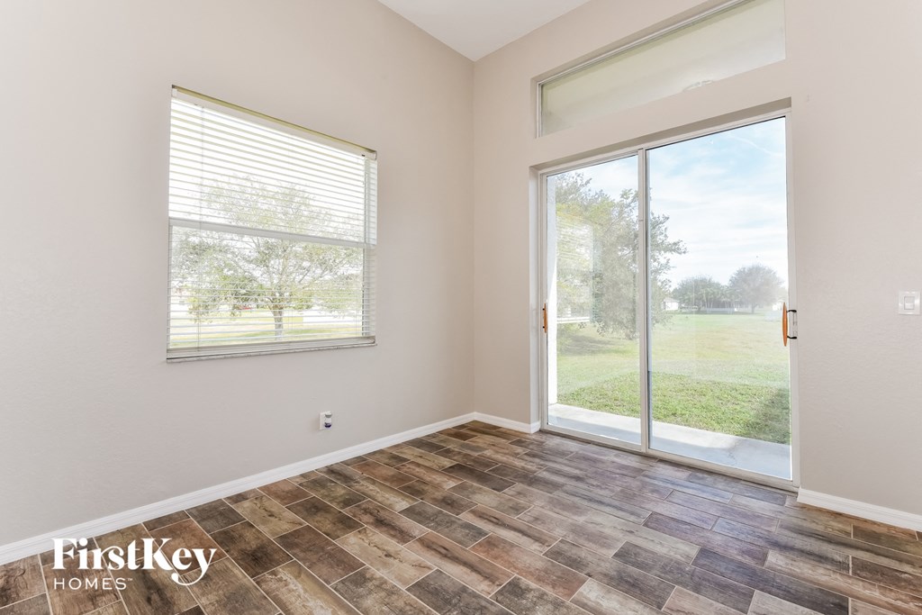 the living room of a home with a large window and a door to the yard