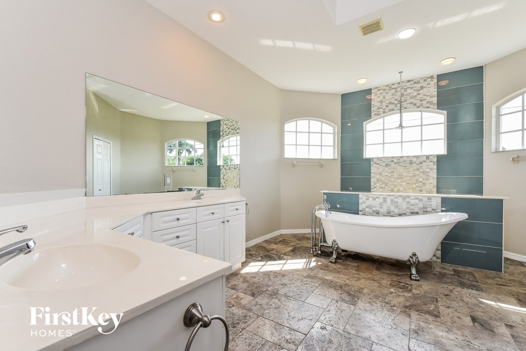 a bathroom with a tub and a sink and a mirror