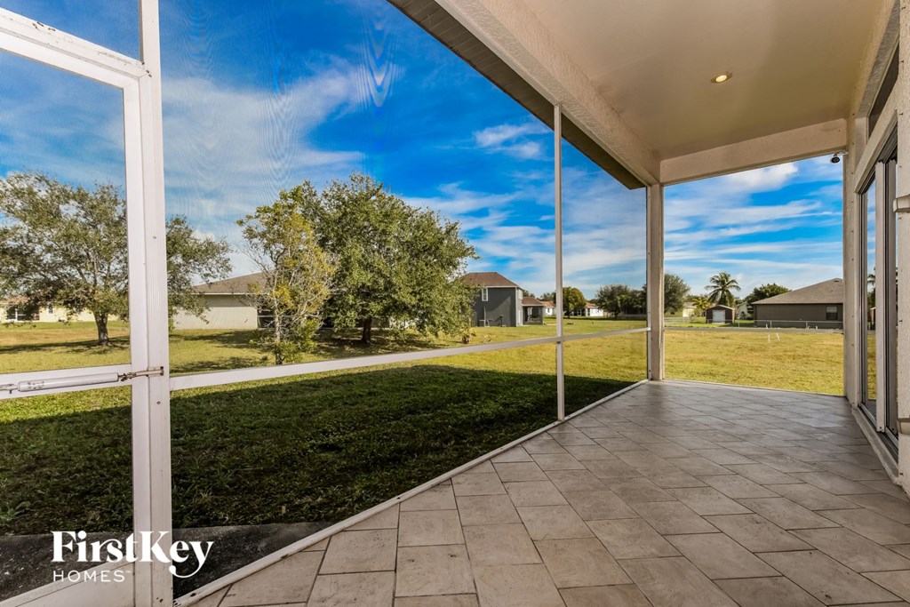 a view of the grass from the patio of a home with glass doors
