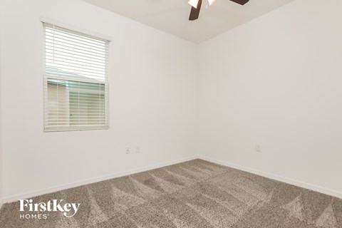 the living room of a home with carpet and a window