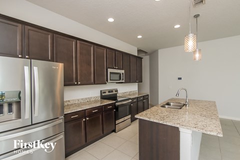 A kitchen with brown cabinets and a granite countertop.