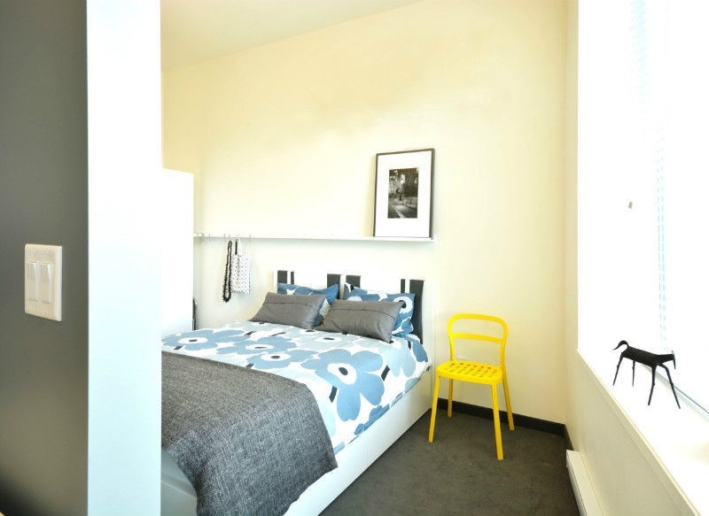a bedroom with a bed and a yellow chair