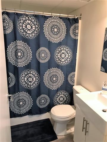 a bathroom with a blue shower curtain and a toilet