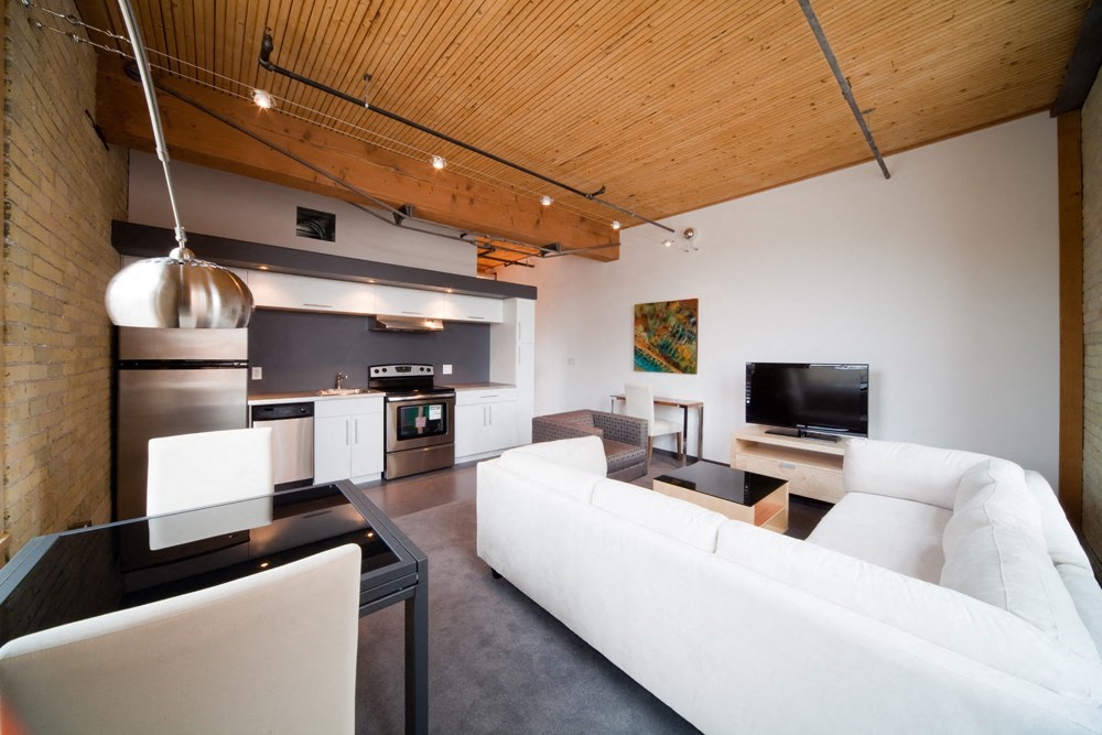 a white living room with a white couch and a television