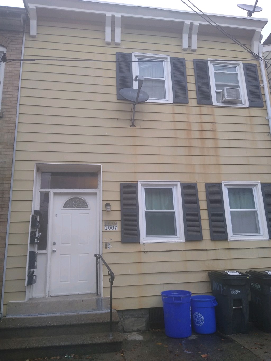 A house with a white door and two windows with black shutters.